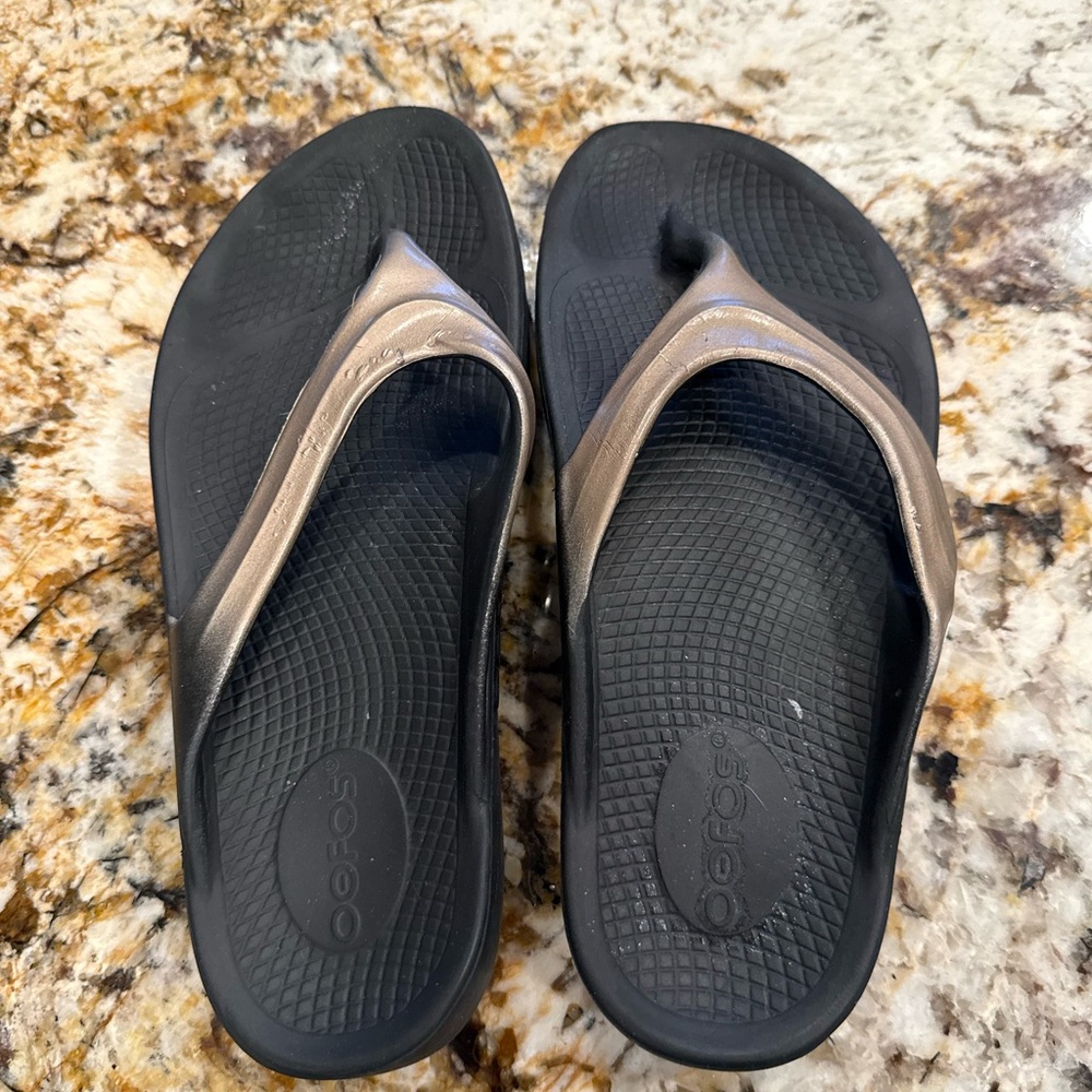 OOFOS OOlala Luxe Flip Flop.  Women’s size 7. Black and Gold Sandals